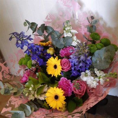 Joyful Wishes - A vibrant hand-tied bouquet featuring fresh seasonal flowers in bright blue, pink, yellow and white tones, beautifully arranged to brighten any occasion, with flowers dependent on seasonal availability.