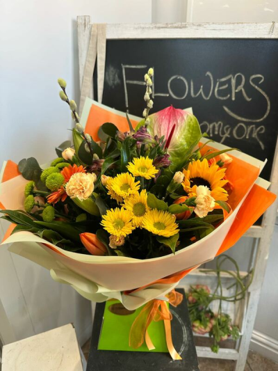 Sunshine Zest - A bright and cheerful bouquet bursting with sunny yellows and vibrant orange tones, finished with fresh greenery.